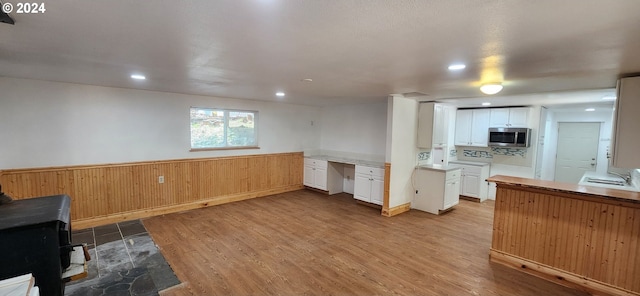 kitchen with white cabinets, sink, and light wood-type flooring