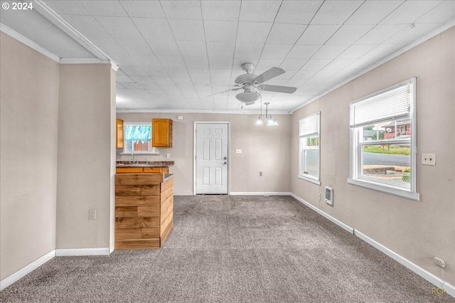 unfurnished living room featuring carpet floors, sink, crown molding, and ceiling fan