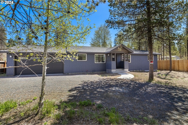 52582 Doe Ln, La Pine, OR 97739 - kitchen with appliances with stainless steel finishes, dark countertops, a sink, a peninsula, and a notable chandelier
