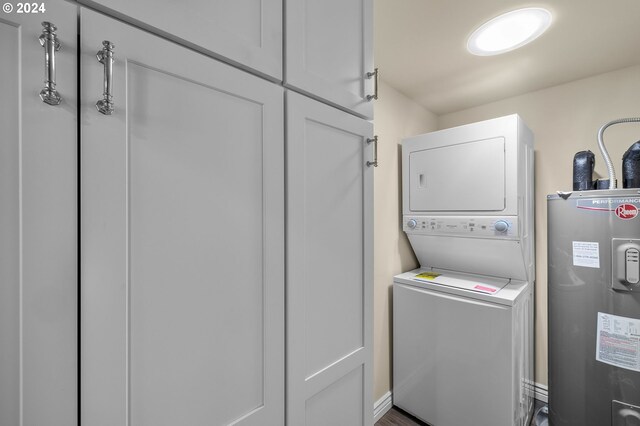 52582 Doe Ln, La Pine, OR 97739 - laundry area featuring stacked washing maching and dryer, cabinet space, and electric water heater