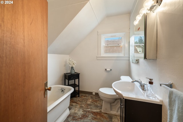 bathroom with a tub, vanity, lofted ceiling, and toilet