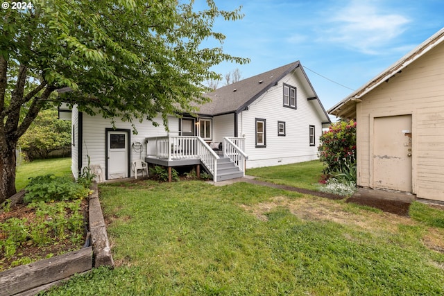 rear view of house featuring a yard and a wooden deck