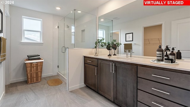 bathroom featuring vanity, walk in shower, and plenty of natural light