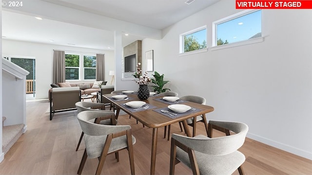 dining space featuring beamed ceiling and light hardwood / wood-style flooring