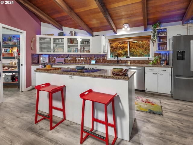 kitchen with sink, vaulted ceiling with beams, stainless steel appliances, and white cabinets