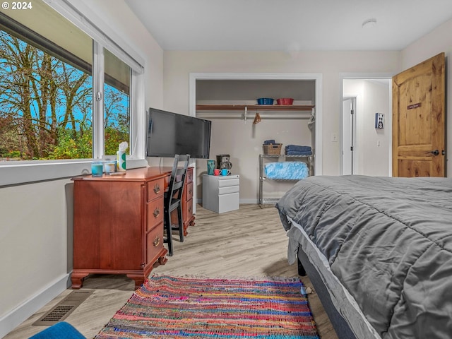 bedroom with light hardwood / wood-style floors and a closet