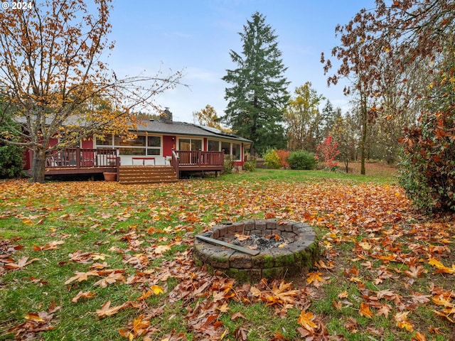 view of yard with a wooden deck and a fire pit