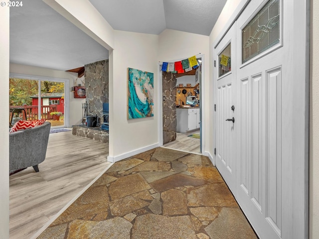 foyer entrance featuring lofted ceiling and light hardwood / wood-style floors