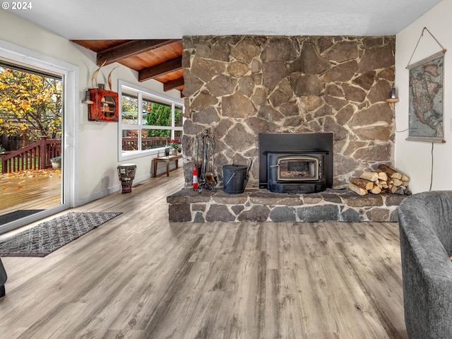 living room with hardwood / wood-style floors, wood ceiling, beamed ceiling, and a wood stove