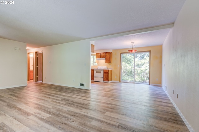 unfurnished living room with a textured ceiling and light wood-type flooring