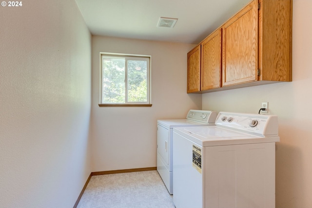 washroom with washer and clothes dryer and cabinets