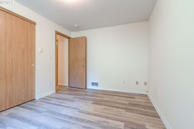 unfurnished bedroom featuring a closet and light hardwood / wood-style floors