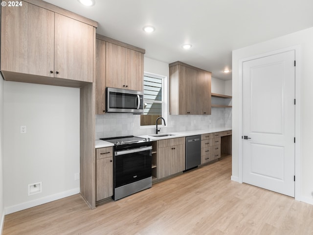 kitchen featuring decorative backsplash, light wood-type flooring, stainless steel appliances, and sink