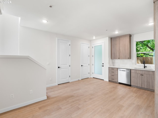 kitchen with decorative backsplash, sink, stainless steel dishwasher, and light hardwood / wood-style flooring