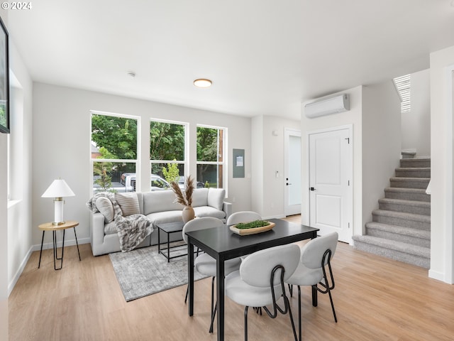 living room featuring light hardwood / wood-style floors and an AC wall unit