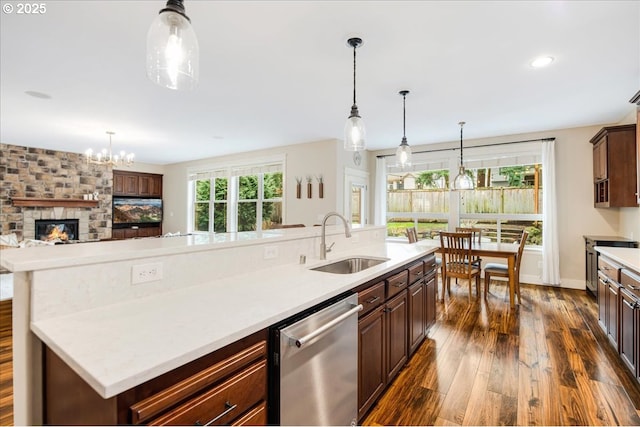 kitchen with dishwasher, open floor plan, dark wood-style flooring, light countertops, and a sink