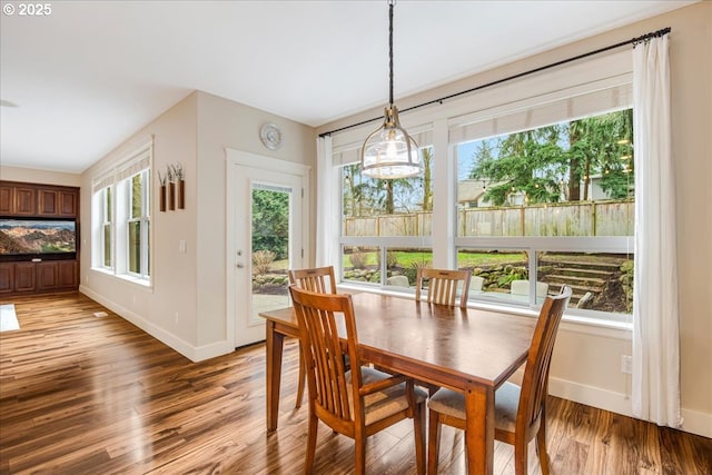 dining room featuring light wood-style floors, baseboards, and a notable chandelier