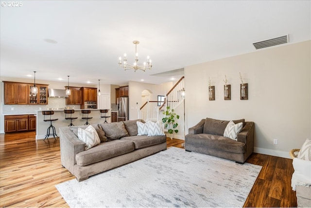 living area featuring recessed lighting, visible vents, baseboards, stairs, and light wood finished floors