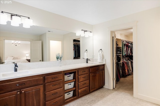 full bath featuring double vanity, ensuite bath, a sink, and a walk in closet