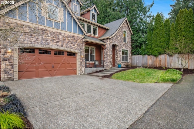 view of front of property featuring driveway, stone siding, and fence