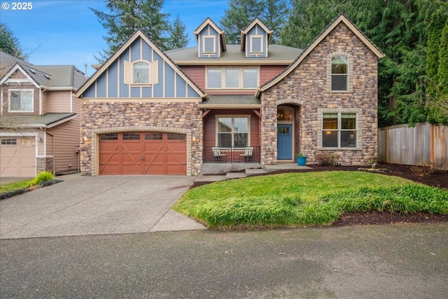 craftsman house with an attached garage, aphalt driveway, a front yard, and fence