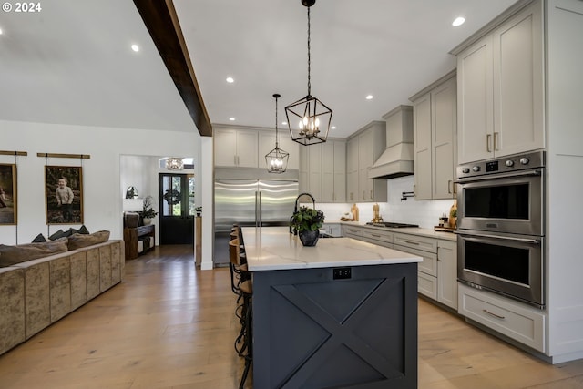 kitchen with a large island, stainless steel appliances, a kitchen breakfast bar, beamed ceiling, and premium range hood