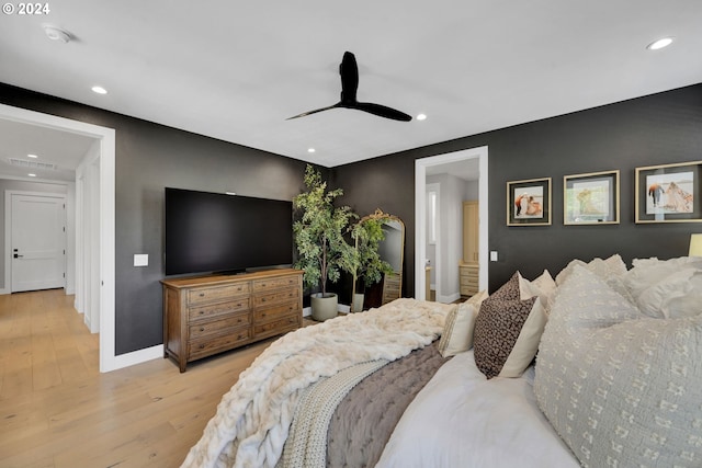 bedroom featuring light hardwood / wood-style floors, ensuite bath, and ceiling fan