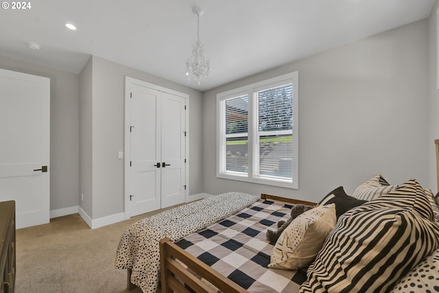 carpeted bedroom featuring a chandelier and a closet