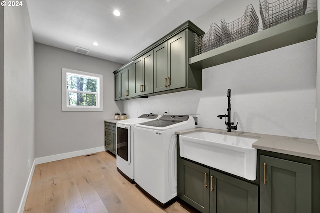 laundry room with cabinets, separate washer and dryer, light hardwood / wood-style flooring, and sink