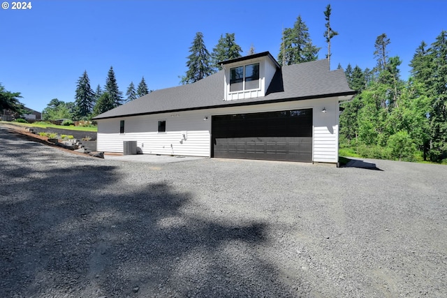 view of side of home featuring a garage and cooling unit