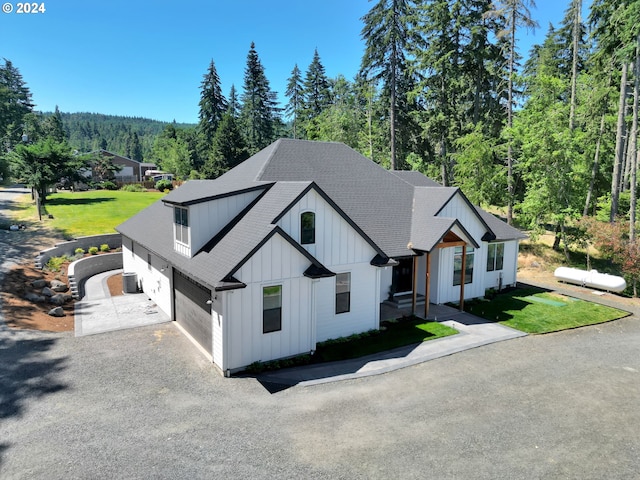 modern inspired farmhouse featuring a garage and a front lawn