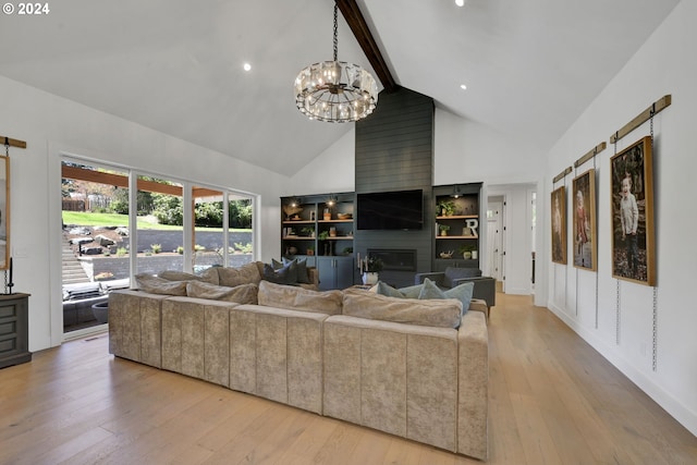 living room with a large fireplace, high vaulted ceiling, light wood-type flooring, and a notable chandelier