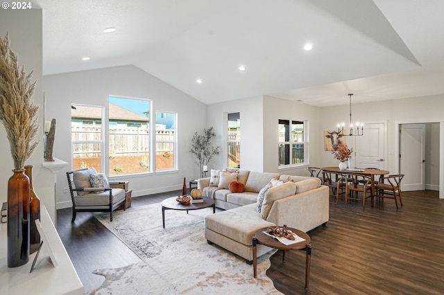 living room with lofted ceiling, an inviting chandelier, dark hardwood / wood-style floors, and a healthy amount of sunlight