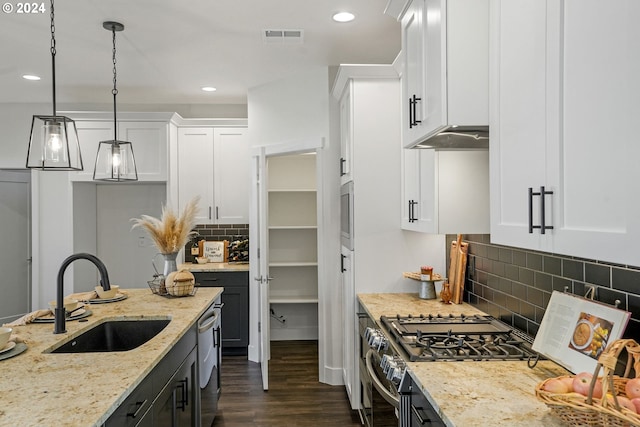 kitchen with sink, light stone counters, pendant lighting, stainless steel appliances, and white cabinets