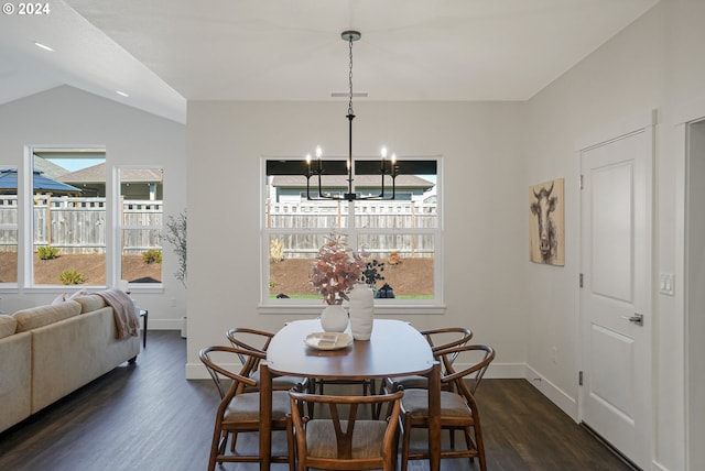 dining room featuring lofted ceiling, dark wood-type flooring, and a notable chandelier