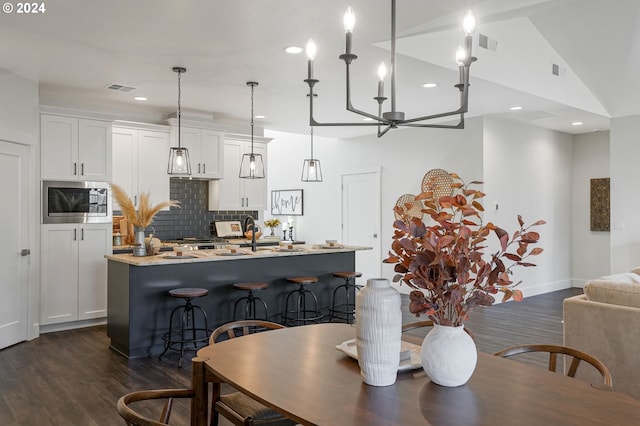 dining room with dark wood-type flooring and lofted ceiling