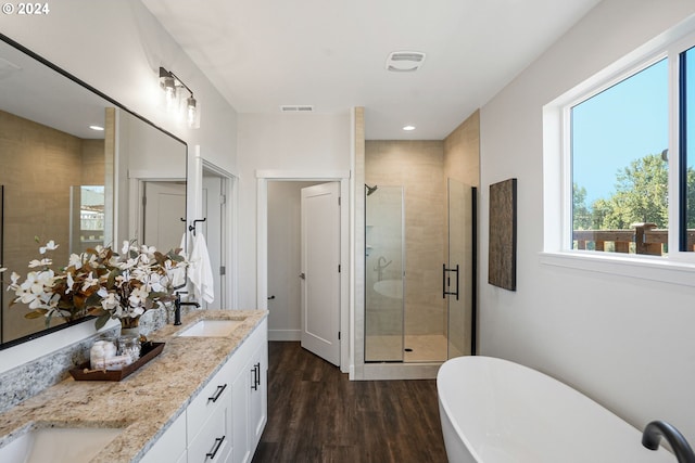 bathroom with vanity, hardwood / wood-style floors, and plus walk in shower