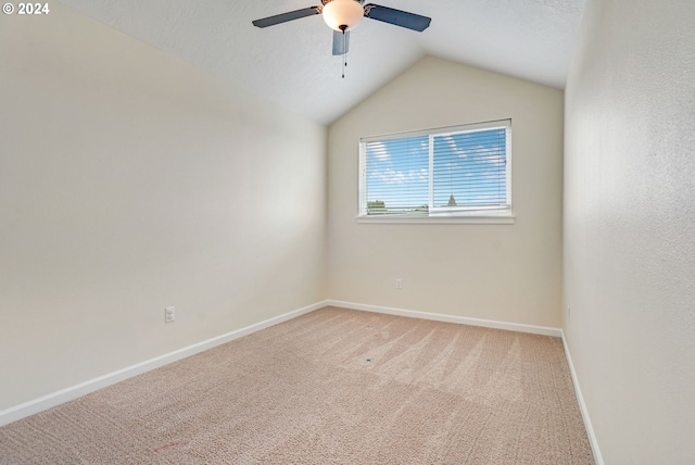 carpeted spare room featuring ceiling fan and lofted ceiling