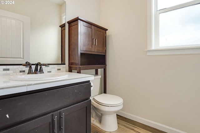 bathroom with hardwood / wood-style floors, toilet, decorative backsplash, and vanity