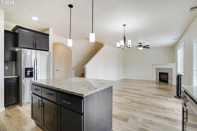 kitchen featuring a kitchen island, stainless steel fridge with ice dispenser, pendant lighting, and light hardwood / wood-style flooring