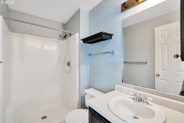 bathroom featuring a shower, toilet, and vanity