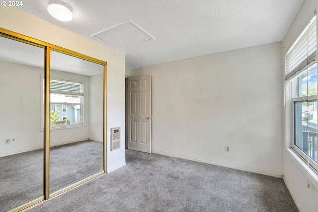 unfurnished bedroom featuring multiple windows, a closet, and light carpet