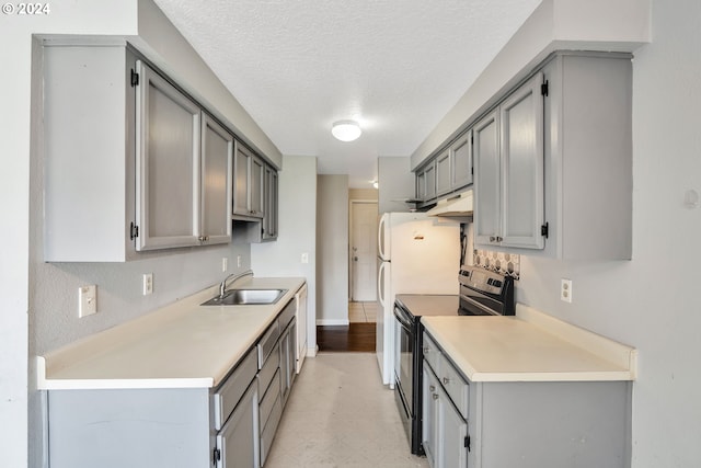 kitchen with sink, a textured ceiling, gray cabinetry, and black electric range