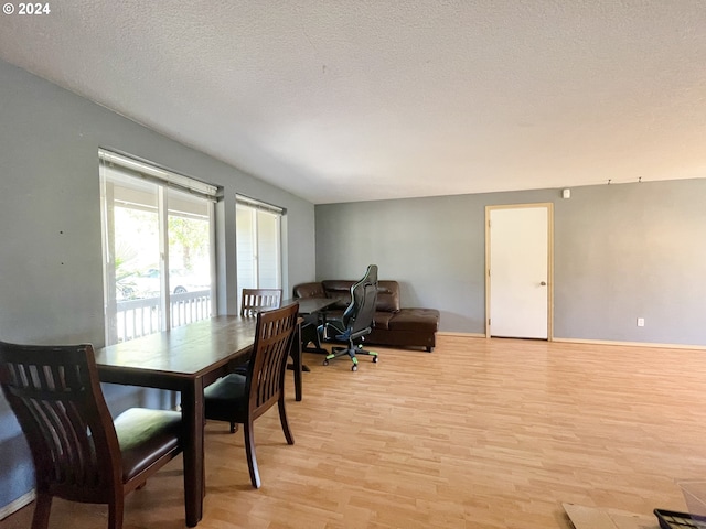 dining room featuring light hardwood / wood-style floors and a textured ceiling