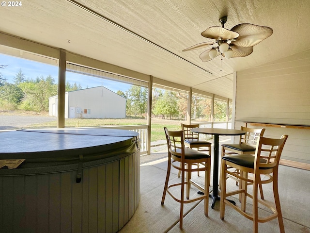 sunroom / solarium with ceiling fan, wooden ceiling, and a hot tub