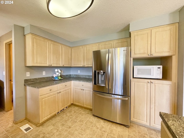 kitchen with a textured ceiling, light brown cabinets, and stainless steel refrigerator with ice dispenser