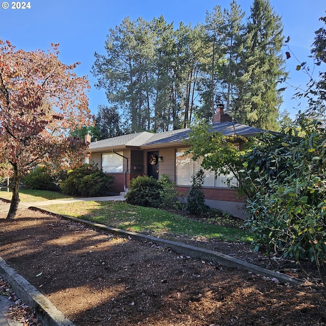 view of front facade featuring brick siding and a chimney