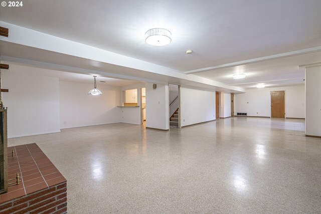 finished basement with stairway, baseboards, and visible vents
