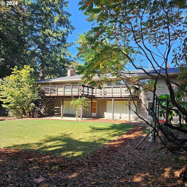 back of property with a wooden deck and a lawn