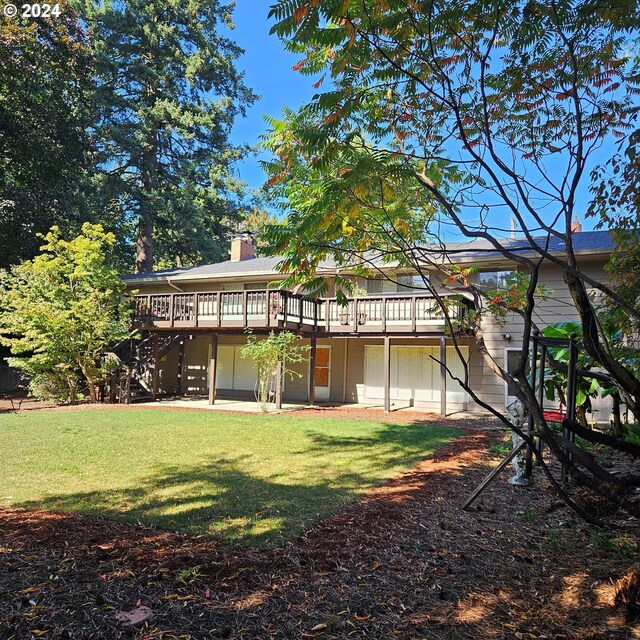 back of house with a chimney, a wooden deck, a yard, and stairway
